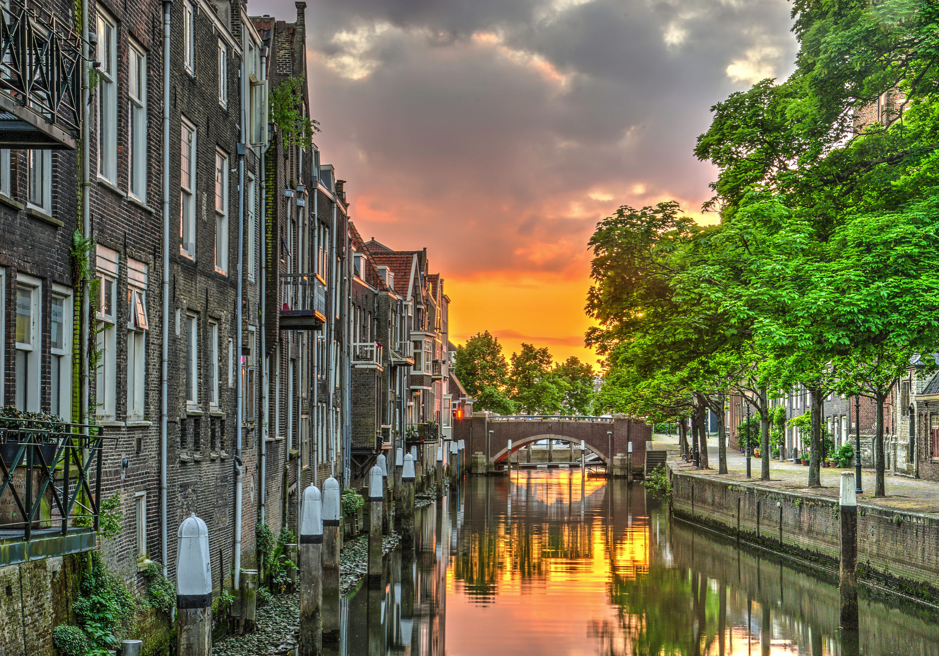 Fiery sunset reflecting in a canal lined with houses in the medieval town centre of Dordrecht, the Netherlands