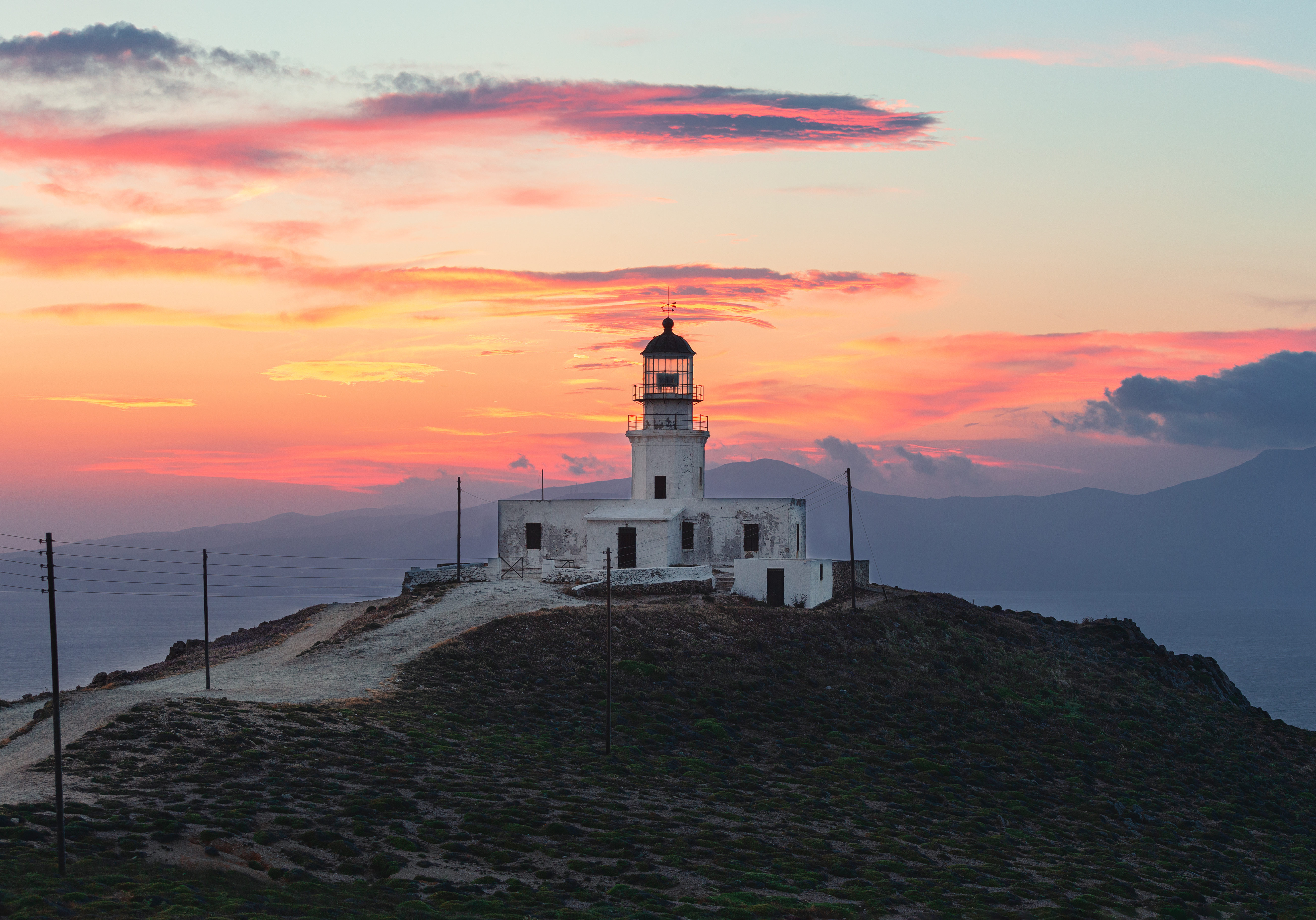 lighthouse-in-mykonos-with-sunset-sky-2021-08-27-15-11-48-utc